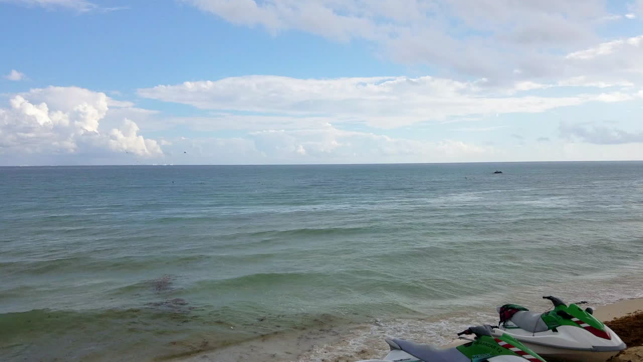 멕시코의 화창한 날 푸른 바다가 내려다보이는 해변에 앉아 있는 두 개의 제트스키