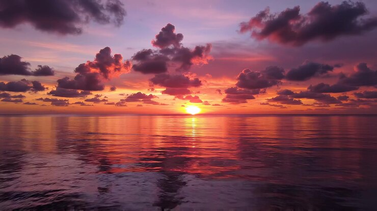 Serene Ocean Sunset with Golden Reflection and Purple Clouds