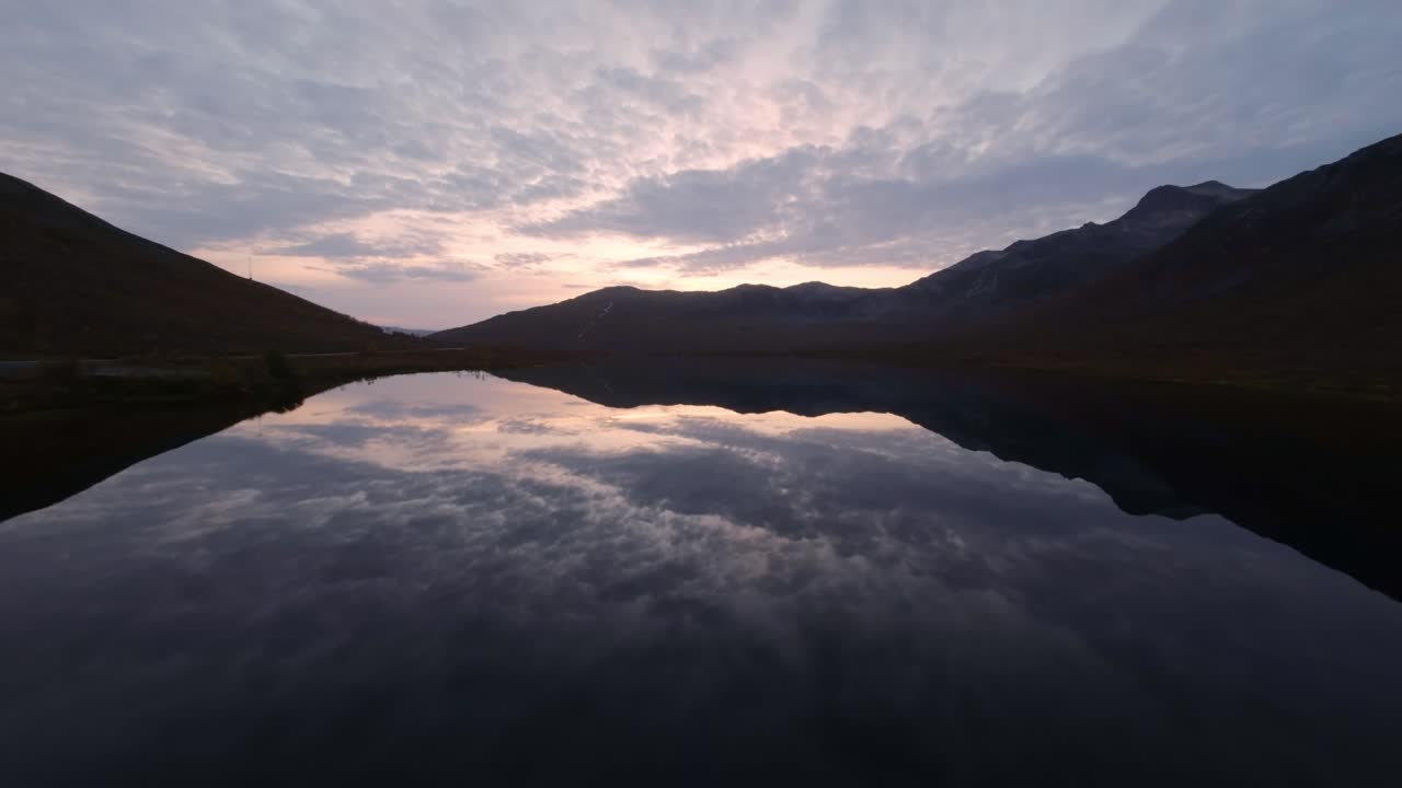 A perfect mirrored lake captured by a FPV drone after sunset in northern Norway