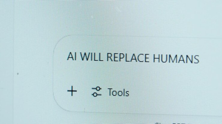 An AI chatbot on a macro screen displaying the phrase 'AI will replace humans