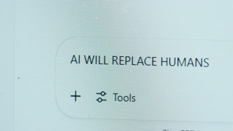 an ai chatbot on a macro screen displaying the phrase 'ai will replace humans
