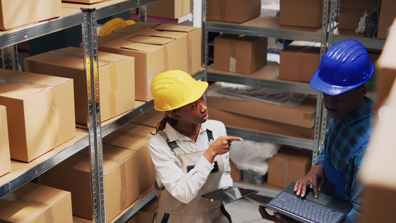 Warehouse workers managing inventory with tablets and laptops