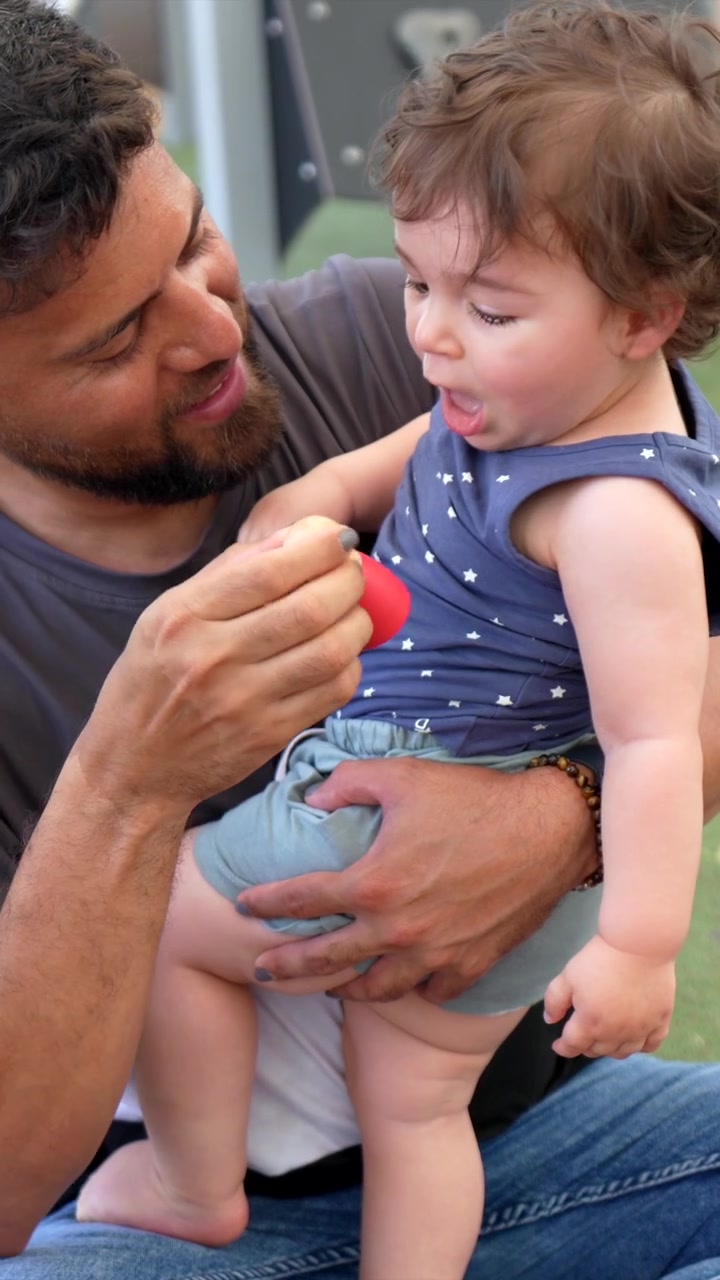 Padre che consola il suo bambino che piange mentre gioca con i giocattoli