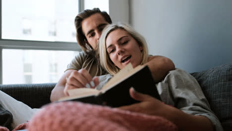 couple reading a book in living room 4k