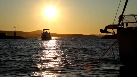 boats and yachts enter and exit marina at sunset in biograd in croatia