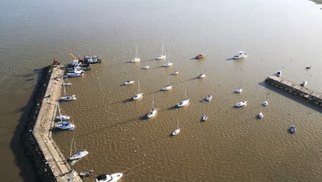 vista aérea volando sobre yates amarrados en la colonia del sacramento marina iluminada por el sol en la costa de uruguay