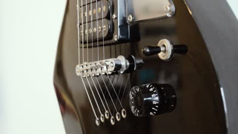 black electric guitar body hanging on a wall, close up