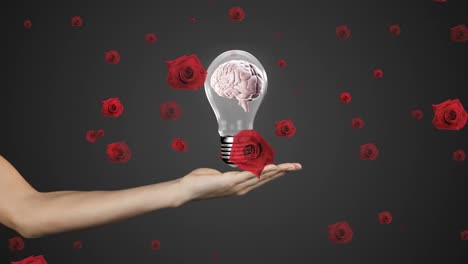 Animation-of-red-roses-over-caucasian-woman-holding-light-bulb-with-brain