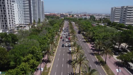 Arial-Tracking-of-a-Large-Group-of-Cars-Leaving-a-Stop-Light-on-a-Wide-Street-near-Modern-Apartment-Buildings