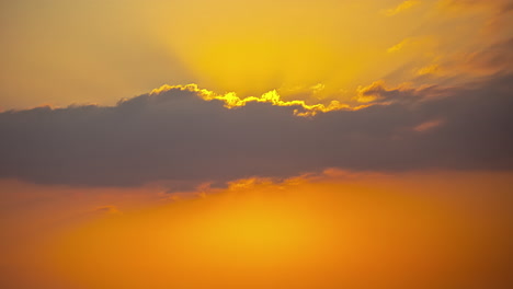 Golden-sun-hiding-behind-flowing-cloudscape,-time-lapse-view
