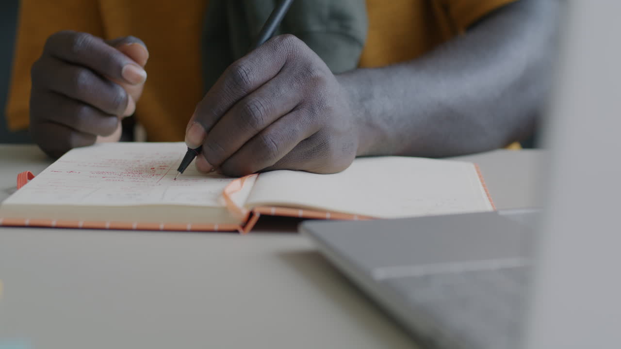 Person writing in a notebook at a desk