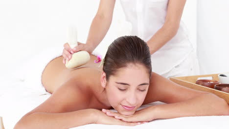 woman enjoying a herbal compress massage