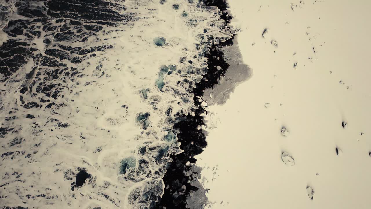 los movimientos cinematográficos de drones muestran una playa de arena negra en islandia filmada por drones en condiciones de nieve