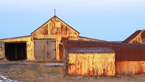 desolado granero islandés en un profundo atardecer naranja, arquitectura nórdica antigua - toma de mano