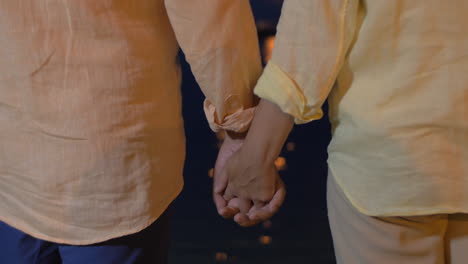 close-up of man and woman holding hands at sea