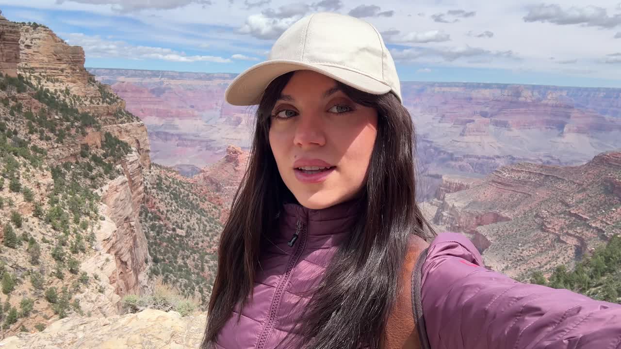 Jovem mulher tirando uma selfie no mirante do Grand Canyon
