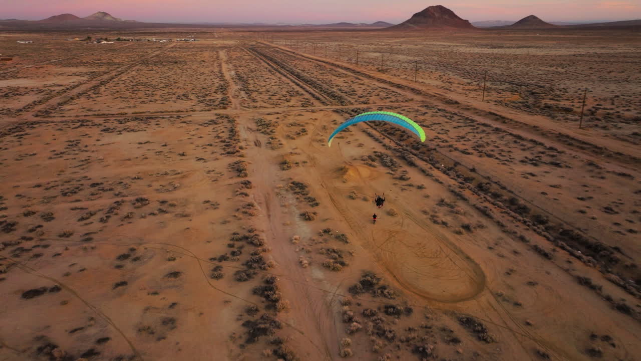멋진 황금빛 일몰 동안 모하비 사막 위로 또 다른 동력 패러글라이더 뒤에 비행