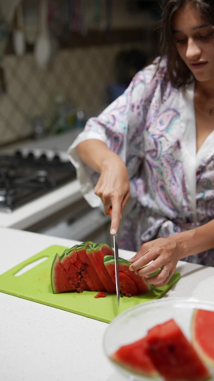 mujer cortando sandía en la cocina
