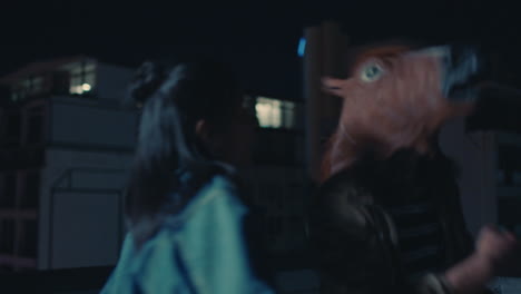 funny-man-wearing-horse-mask-dancing-with-friends-on-rooftop-having-fun-performing-silly-dance-moves-celebrating-weekend-together-in-urban-city-skyline