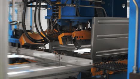 Robotic-equipment-assembling-washing-machine-from-metal-detail-at-plant