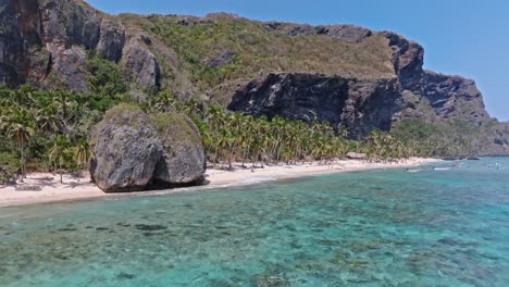 Secret-paradise-beach-hidden-under-huge-cliffs-and-gigantic-rocks,-aerial