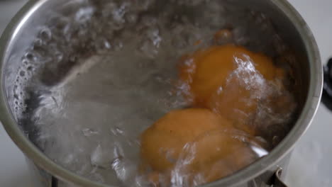 two eggs boiling in a pan