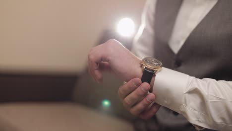 man put on wrist watch, groom dresses, male businessman waiting for meeting, hand with clock