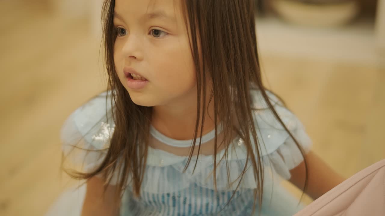 어린 소녀가 집에서 아기 여동생과 즐겁게 놀고 있습니다. 이 순간은 편안한 실내 환경에서 형제자매의 유대감과 가족 사랑을 포착합니다.