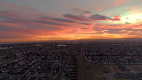 a drone flies backward revealing an epic sunrise over northern colorado