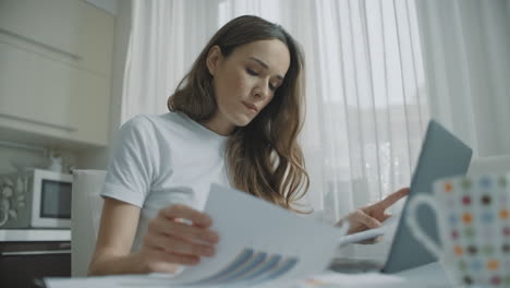 thoughtful woman working with documents at home. worried business woman