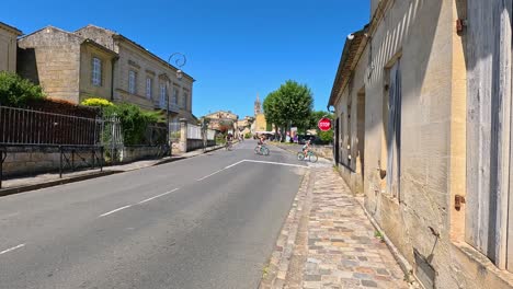 cyclists ride through scenic saint-émilion, france