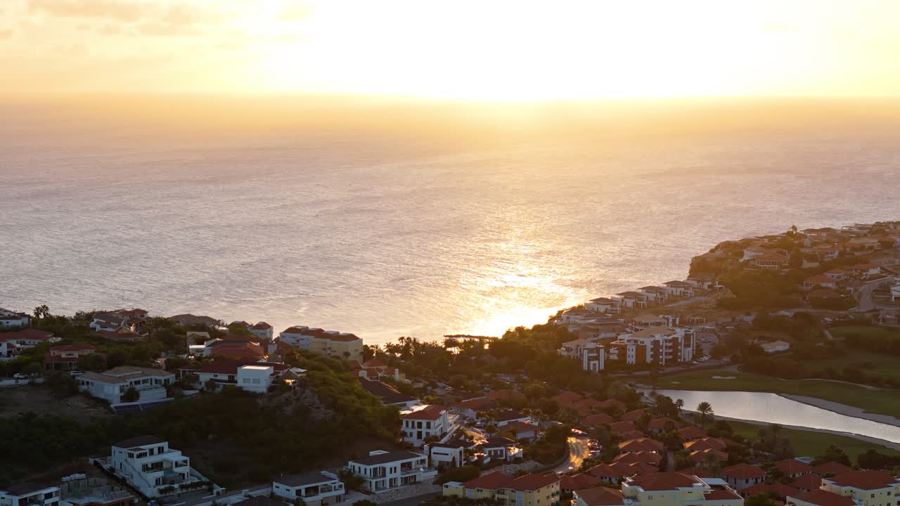 La luce del sole dell'ora d'oro si riflette sull'oceano Caraibico, viste maestose di un resort tropicale in riva al mare