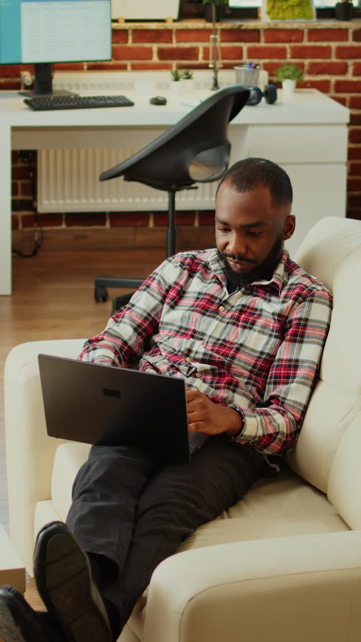 Man working on laptop on sofa