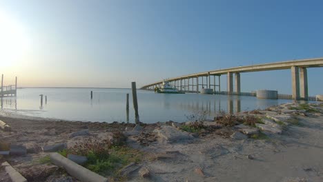 Small-barge-pusher-towboat-motoring-along-the-Intercoastal-Waterway-in-Laguna-Madre-near-the-JFK-Memorial-Causeway-near-sunset