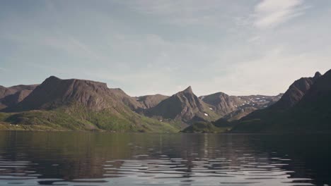 Hills-Reflected-On-Crystal-Clear-River-Under-Bright-Sky-In-Norway