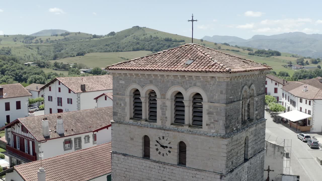 Close aerial shot of historic church tower with clock in Ospitalea village, Irissarry, France
