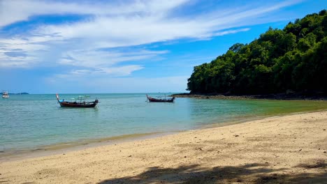 Two-long-tail-boats-anchiored-near-sea-shore-during-a-sunny-day-in-Phuket-Thailand