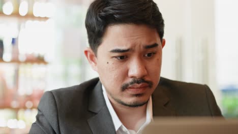 slow motion scene of middle east businessman frowning on face during working with colleagues on laptop in office room for business concept