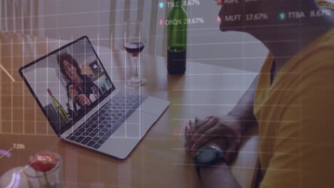 mixed race man sitting at table using laptop making video call with male friend at home in isolation