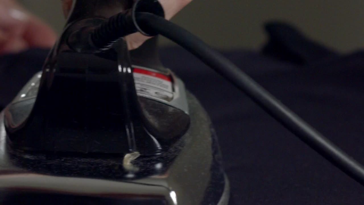 섬세한 직물에 대한 철의 근접 - 개념: 패션 산업 폐기물과 손상