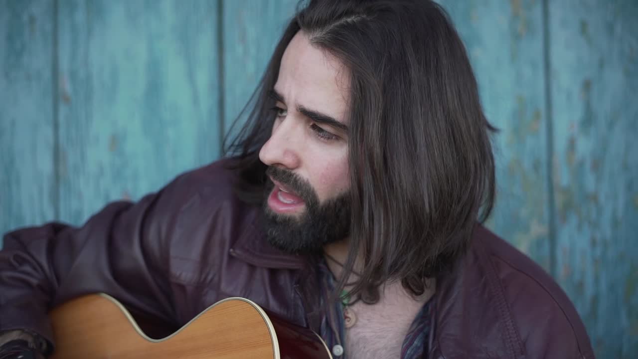 hombre tocando la guitarra acústica al aire libre