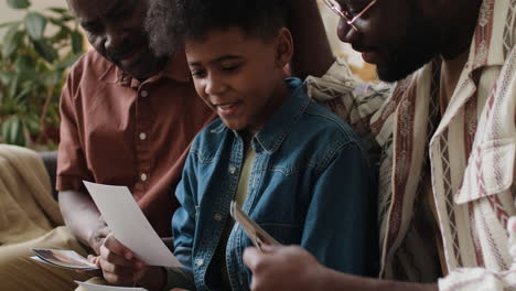 black men and boy looking at pictures in the living room