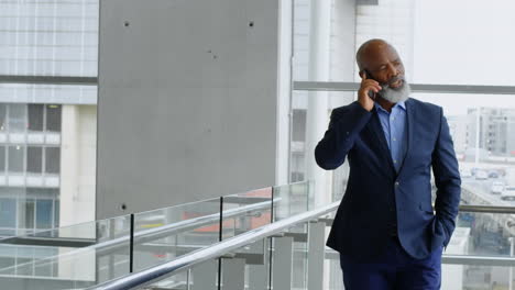 réseau d'icônes numériques contre un homme d'affaires afro-américain en train de parler sur smartphone au bureau