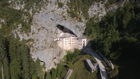 Drone-shot-over-Predjama-near-Predjama-Castle,-connected-to-Postojna-cave