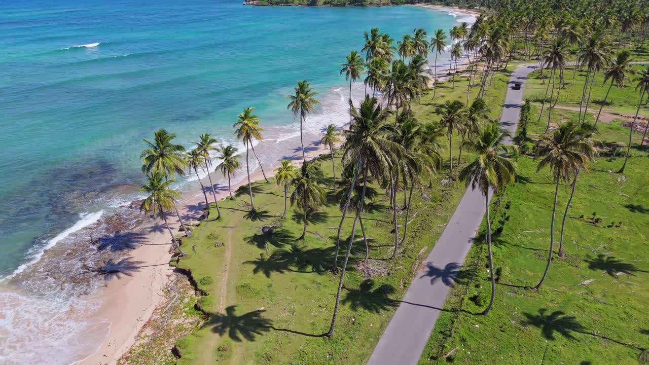 Auto che guida lungo una strada esotica e panoramica, spiaggia Playa La Entrada, Cabrera nella Repubblica Dominicana. Vista aerea da drone