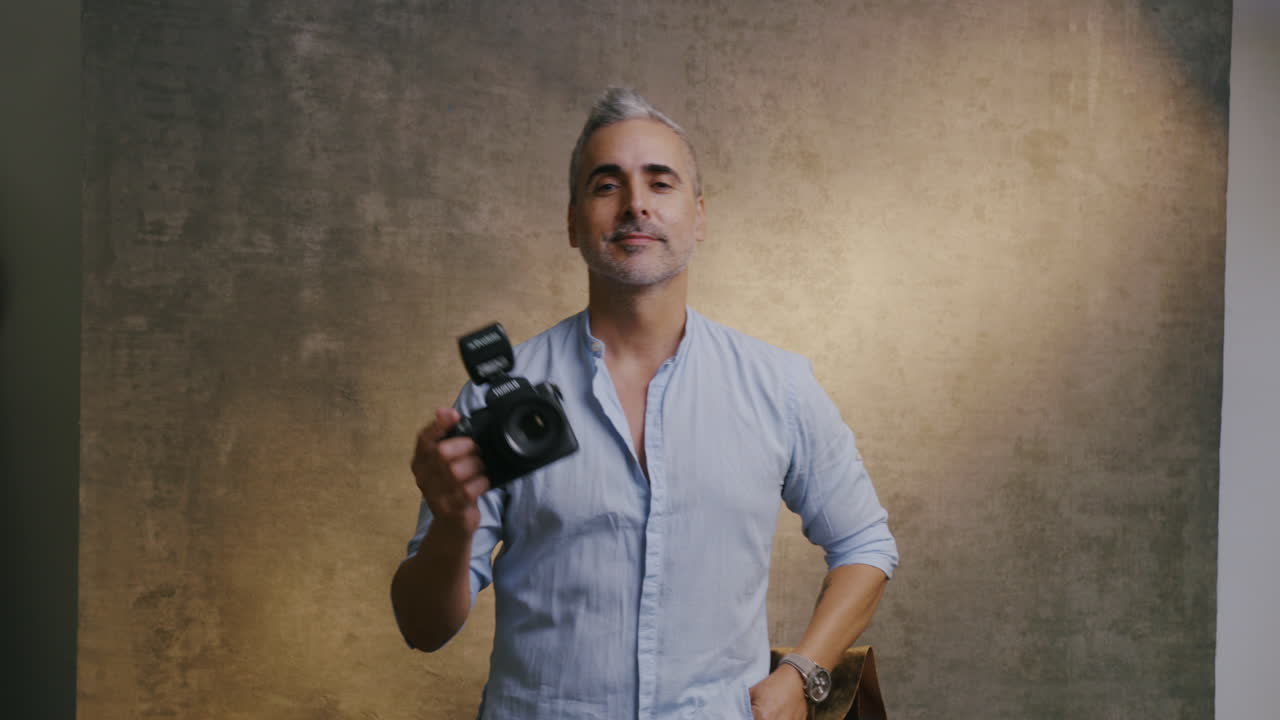 African photographer posing and holding a camera, looking into the lens with a focused expression, showcasing confidence and creativity