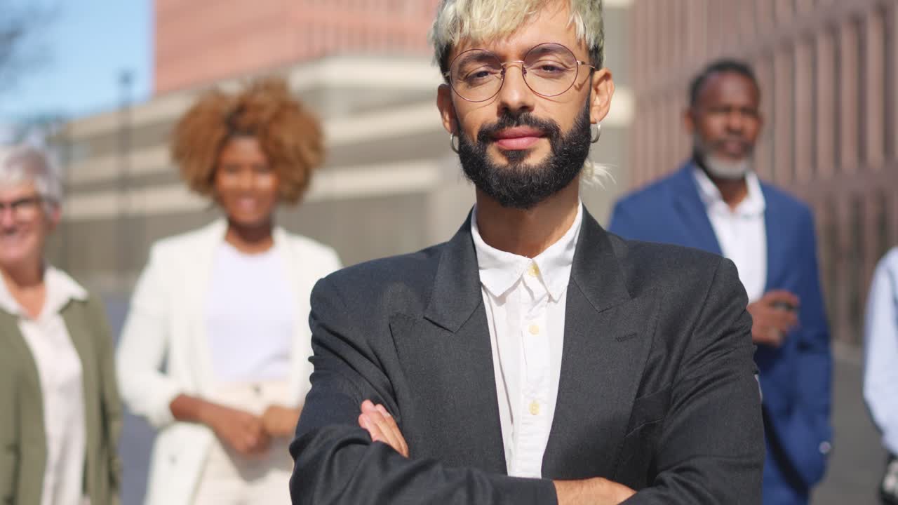 Young businessman crossing arms next to colleagues outdoors