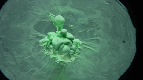 tinta verde explotando en el agua dando forma a formas místicas, nubes, figuras bajo el agua