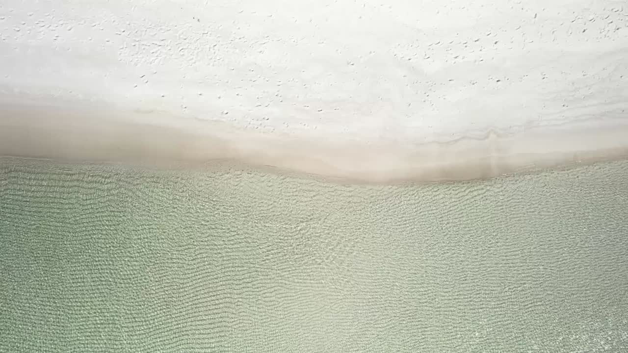 여름 에 비어 있는 해변 의 해안선 에서 물 이 물결 을 일으키고 있다