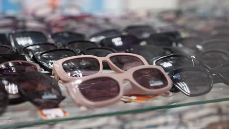 a close-up view of a variety of sunglasses on display in a store, with focus on the different styles and colors of the sunglasses